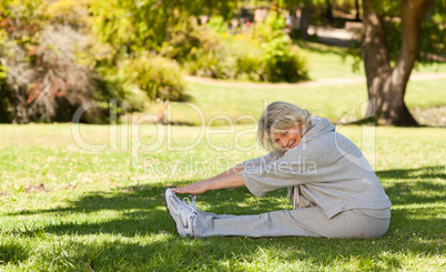 Senior woman doing her streches in the park