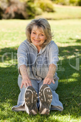 Senior woman doing her streches in the park