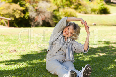 Senior woman doing her streches in the park