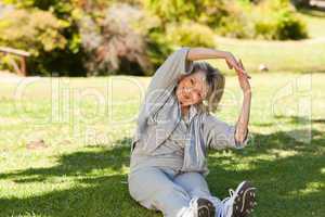 Senior woman doing her streches in the park
