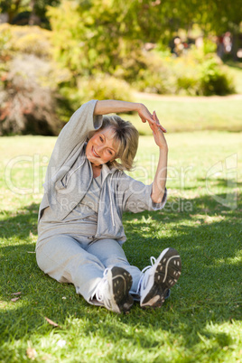 Senior woman doing her streches in the park