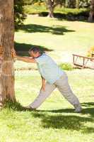 Mature man doing his streches in the park