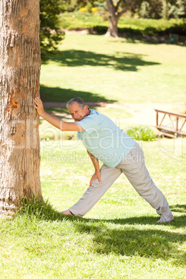 Mature man doing his streches in the park