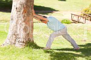 Mature man doing his streches in the park