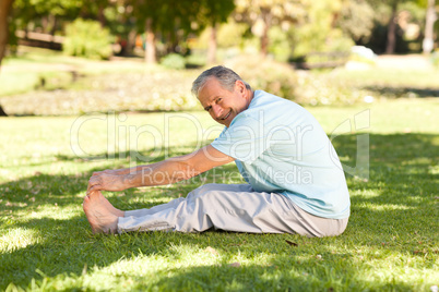 Mature man doing his streches in the park