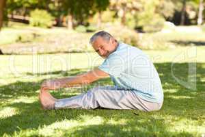 Mature man doing his streches in the park