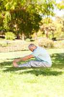 Mature man doing his streches in the park