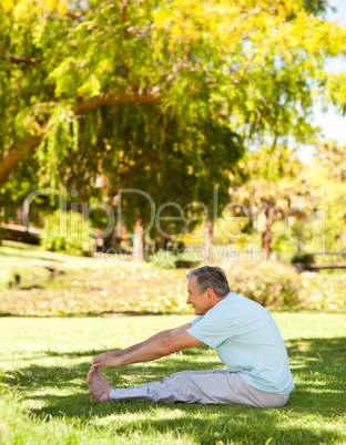 Mature man doing his streches in the park