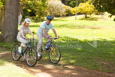 Retired couple mountain biking outside