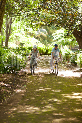 Elderly couple mountain biking outside