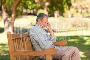 Mature man phoning in the park