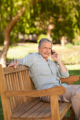 Mature man phoning in the park