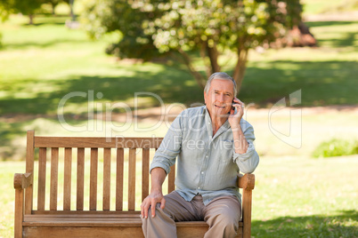 Retired man phoning in the park