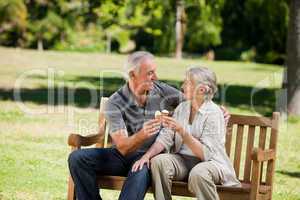 Senior couple eating an ice cream on a bench