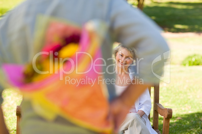 Mature man offering flowers to his wife