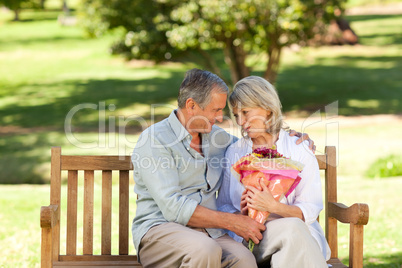 Mature man offering flowers to his wife
