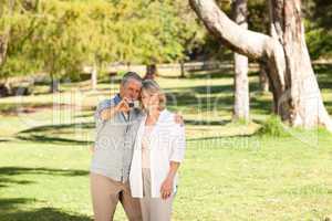 Elderly couple taking a photo of themselves in the park