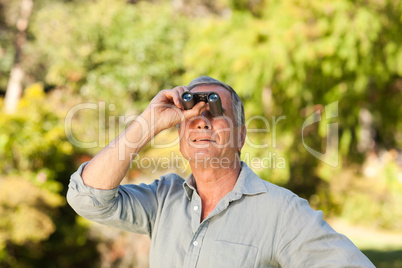 Elderly man looking at the sky with his binoculars