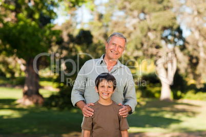 Grandfather with his grandson looking at the camera in the park
