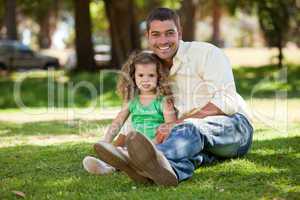 Father with his daughter sitting on the garden