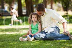 Father with his daughter sitting on the garden