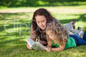 Woman with her daughter reading a book