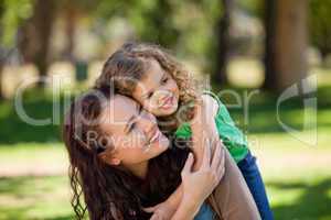 Woman hugging her daughter in the park