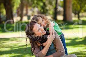 Woman hugging her daughter in the park