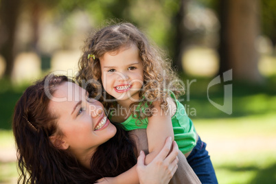 Woman hugging her daughter in the park