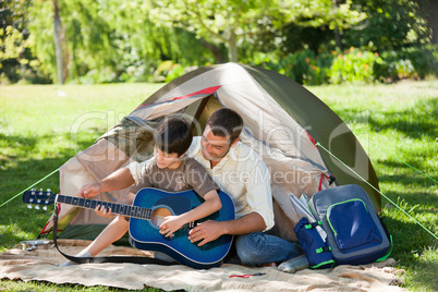 Father playing guitar with his son