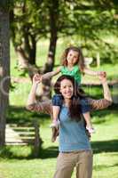 Mother giving daughter a piggyback