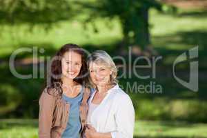 Mother with her daughter looking at the camera in the park