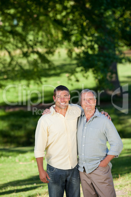 Father and his son looking at the camera in the park