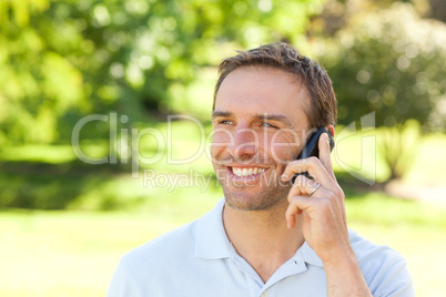 Handsome man phoning in the park