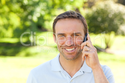Handsome man phoning in the park