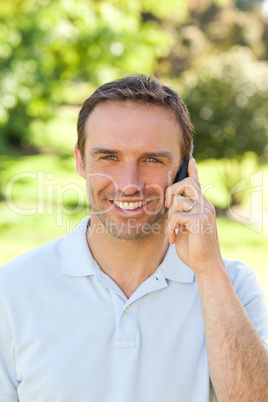 Handsome man phoning in the park