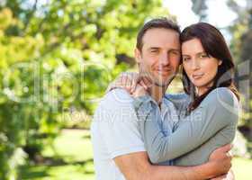 Radiant couple hugging in the park