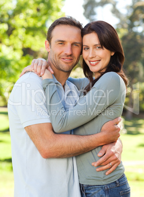 Radiant couple hugging in the park