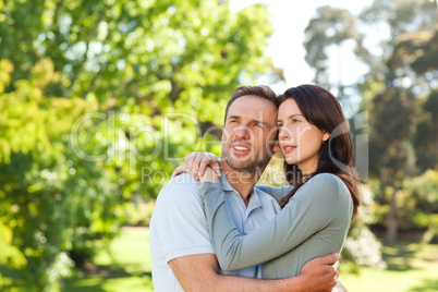 Radiant couple hugging in the park