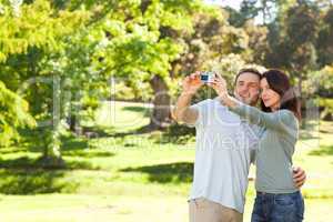 Couple taking a photo of themselves in the park