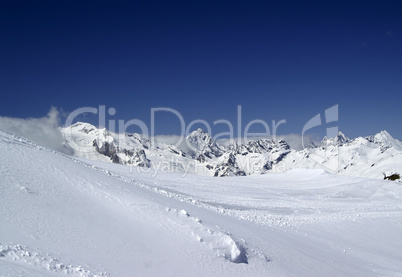 Ski slope against mountain peaks