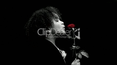 Young black girl/child with curly hair holding a red rose against black background 4