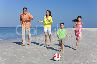 Mother, Father and Children Family Running With Football on Beac