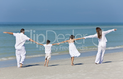 Mother, Father and Children Family Holding Hands At Beach
