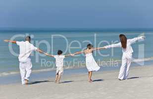 Mother, Father and Children Family Holding Hands At Beach