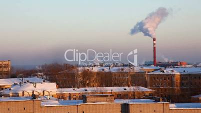 winter urban landscape and pipe with smoke at horizon