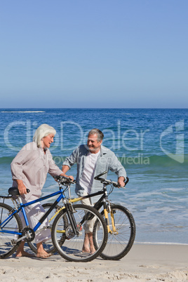 Retired couple with their bikes on the beach