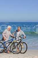 Retired couple with their bikes on the beach