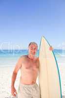 Senior man with his surfboard