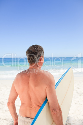 Senior man with his surfboard